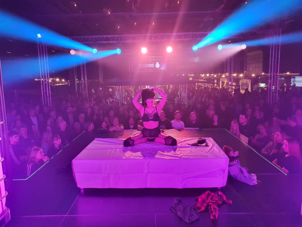 Scen och publik i rosa och blått ljus på en tidigare Erotic World-mässa